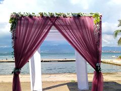 17C A pink drape outdoor wedding arch on the beach framing Kingston Harbour beyond at Grand Port Royal Hotel Marina Kingston Jamaica